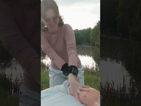 beautiful girl massaging Eveline  feet on riverbank